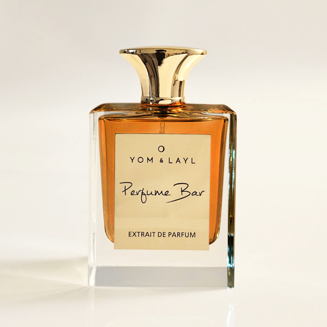 Perfume bottle with gold cap and label on a light background
