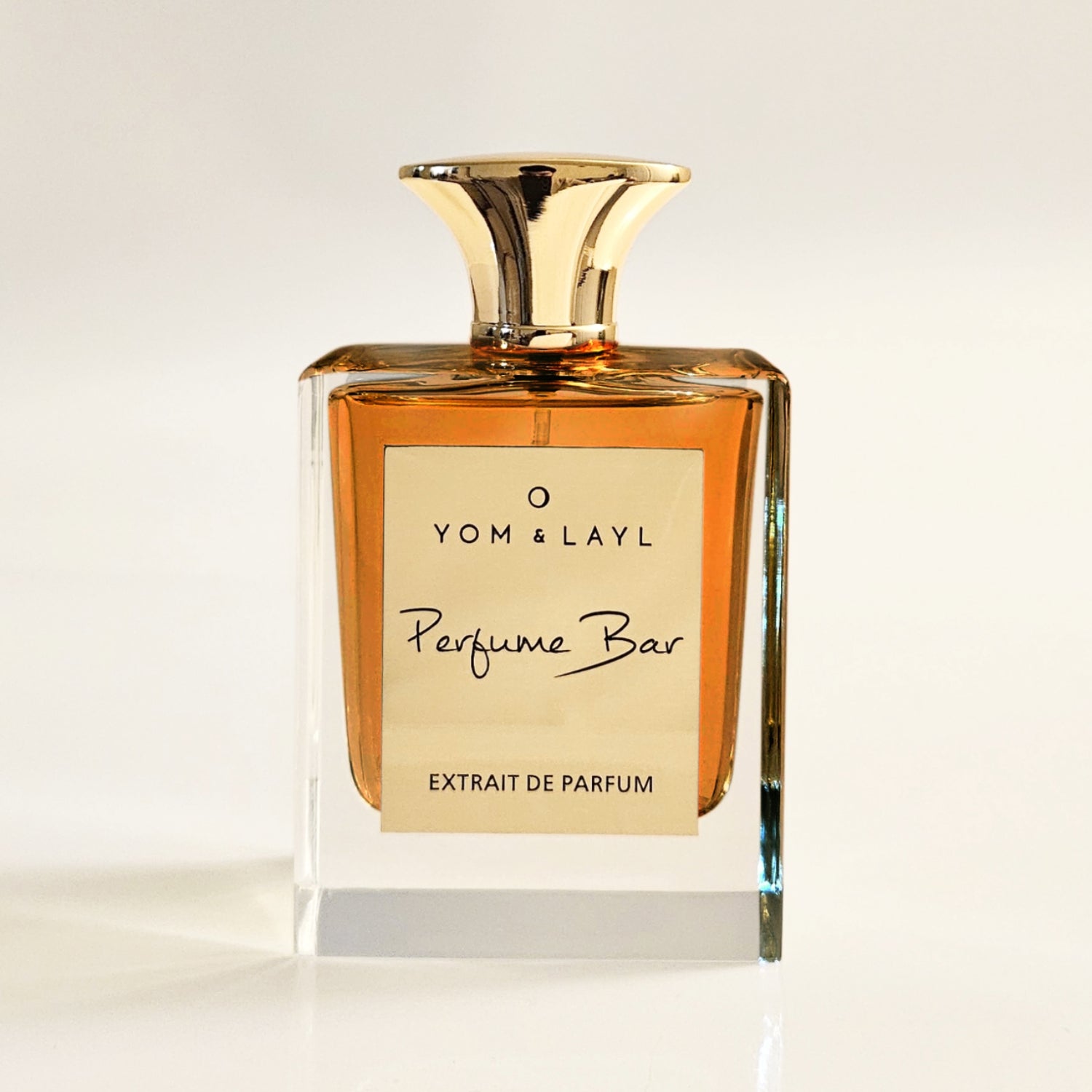 Perfume bottle with gold cap and label on a light background